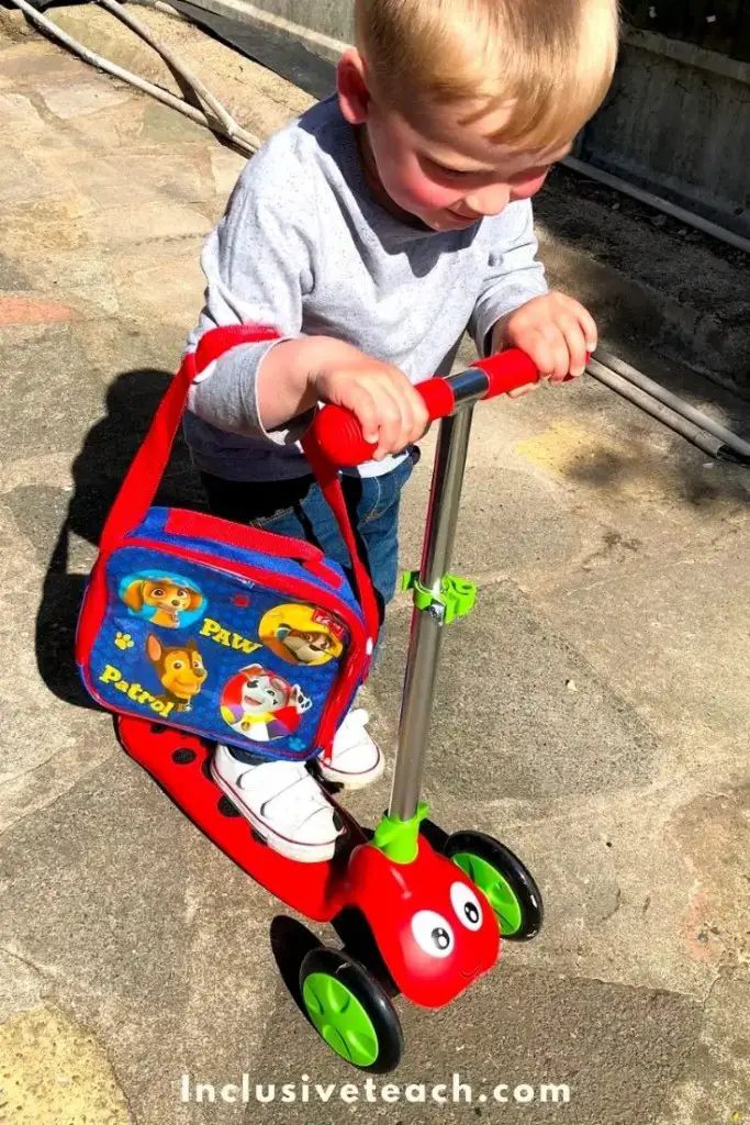 a toddler on a red scooter gross motor activity